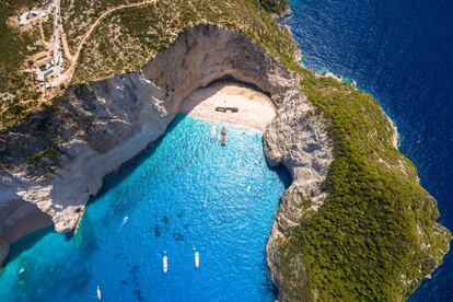 Zante —en griego, Zákynthos, por el nombre del hijo de Dárdano, hermano del mítico rey de Arcadia, a quien asesinó para usurpar el trono— es la tercera isla jónica en tamaño, mucho más tranquila que la vecina Corfú y conocida sobre todo por la playa de Navagio o del Naufragio (en la foto), en la bahía de los Contrabandistas, solo accesible en barco. Una media luna de arena tan blanca como la tiza donde yace la osamenta de un barco varado, entre un anfiteatro de paredes de creta y un mar de intenso color turquesa. De ese color son también las grutas del acantilado de Skinari, un conjunto de túneles y bóvedas excavadas por el mar en la costa norte de Zante. La más famosa es la Blue Grotto (gruta azul), que puede recorrerse en barco.