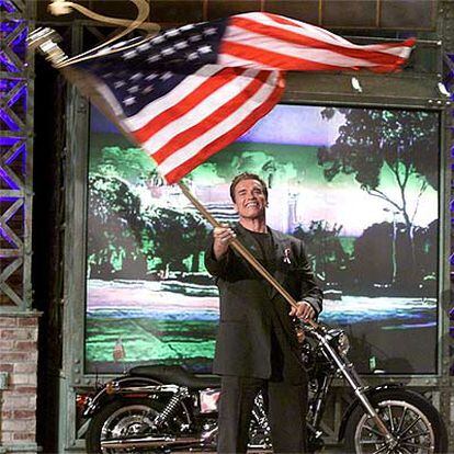 Arnold Schwarzenegger ondea la bandera norteamericana durante su aparición en un programa de televisión de la NBC.