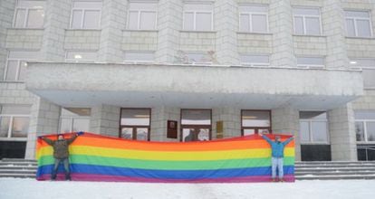 Los activistas Nikolai Alekseyev y Alexey Kiselev sostienen una bandera gay en una protesta. 