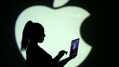 Silueta del logotipo de Apple con una mujer y un ordenador. 