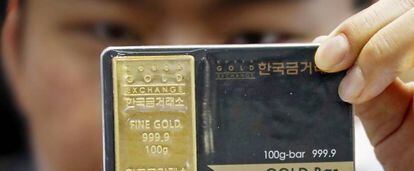 Un trabajador del Korea Gold Exchange muestra lingotes de oro en Se&uacute;l (Corea del Sur).