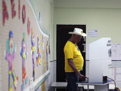 Un hombre con camisa amarilla vota en una escuela en Brasilia.