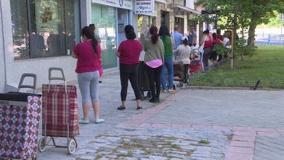 Cola de personas esperando a recibir alimentos y productos de primera necesidad en Madrid.