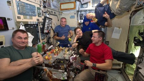 Astronautas celebrando una comida especial, en la Estación Espacial Internacional.