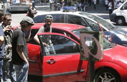 Un grupo de toxicómanos se sube a una cunda justo delante de un coche patrulla del Cuerpo Nacional de Policía.
