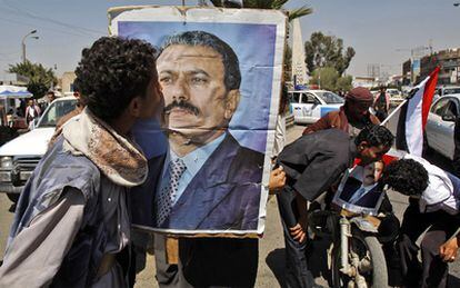 Un hombre besa un retrato de Ali Abdalá Saleh, presidente de Yemen desde 1978, en Saná. La capital del país ha vivido hoy nuevos choques entre manifestantes antigubernamentales y grupos convocados por el régimen para hostigar a los primeros y atajar las protestas.