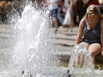 Unos turistas se refresca en una fuente en Valencia.