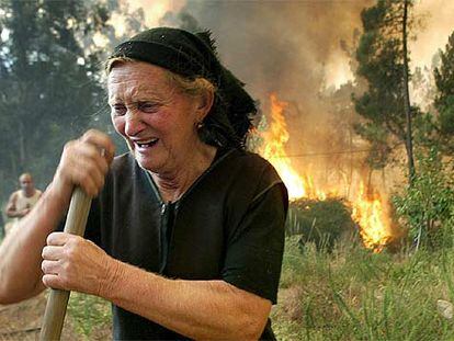 Una mujer llora ante las llamas que amenazan el pueblo de Outeiro, distrito de Viseu, el pasado martes.
