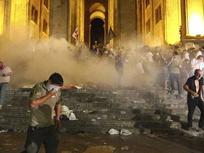 Manifestantes se protegen de una carga de gases lacrimógenos, este viernes en Tblisi.