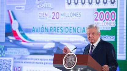 In this photo provided by Mexico's Presidential Press Office, President Andres Manuel Lopez Obrador stands in front of an image of a raffle ticket featuring the presidential plane, in his morning press conference at the National Palace in Mexico City, Friday, Feb. 7, 2020. Lopez Obrador announced that the raffle of the Boeing Dreamliner will be symbolic, awarding total prize money of $100 million, which lottery tickets state is "equivalent to the value of the presidential jet." (Mexico's Presidential Press Office via AP)