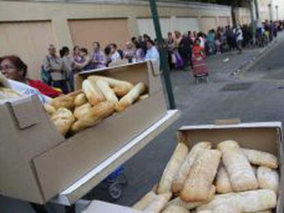 Cola de personas espera un reparto de comida del Banco de Alimentos en Valencia.