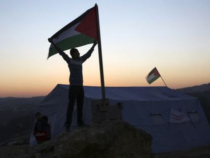 Un activista alza una bandera palestina en el campamento de Beit Iksa, cerca de Ramala. 