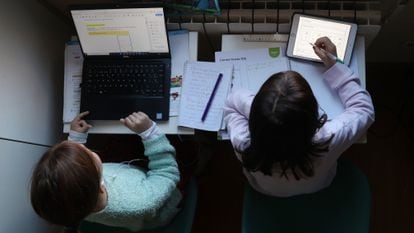 Two girls do their homework at home during the coronavirus pandemic.
