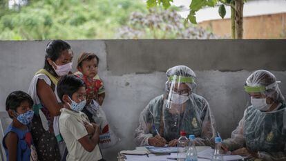 Personal sanitario toma los datos a una mujer con sus hijos para la vacunación contra la covid-19 en Manaos, Brasil.