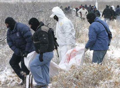 Peritos forenses recogen los cuerpos de las víctimas del tiroteo en Villa Ahumada.