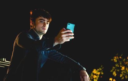 Daniel Radcliffe mirando en soledad la pantalla de su 'smartphone' en la película 'Amigos de más' (2013).