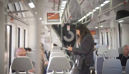 Una interventora controla si els passatgers viatgen amb bitllet en un tren de Rodalies.