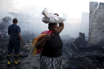 Una mujer camina tras un incendio en el mercado central de Puerto Príncipe (Haití).