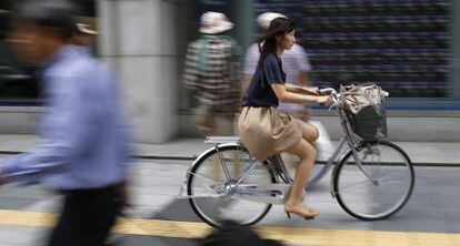 Una mujer pasa en bicicleta por una calle de Tokio en septiembre pasado. 