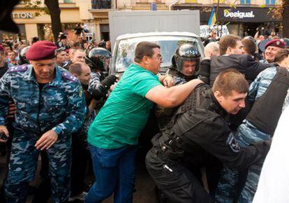 Policías antidisturbios despejan el paso a un vehículo en el tribunal de Pecherskyi, en Kiev, Ucrania. Los seguidores de la ex primera ucraniana Yulia Timoshenko intentaron bloquear el automóvil que debía trasladarla a la cárcel.