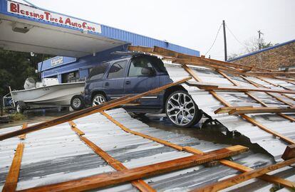 Partes de un techo se encuentran encima de un automóvil estacionado en Blessings Tire and Auto Care después del paso de la tormenta en Bay City, Texas,.