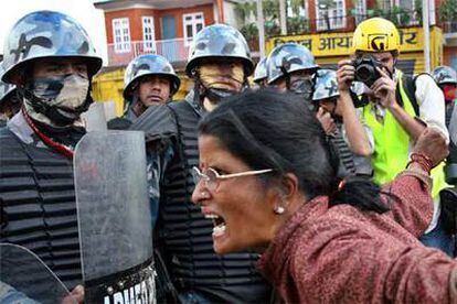 Una manifestante protesta rodeada de policías ayer en Katmandú.