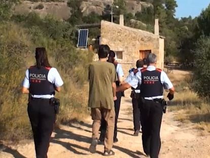 Uno de los supremacistas detenidos en la masía de La Pobla de Cérvoles (Lleida), escoltado por agentes de los Mossos d'Esquadra.