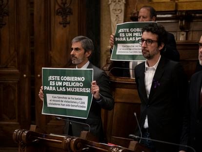 El regidor de Vox Liberto Senderos Oliva, en segundo plano, sostiene un cartel contra la violencia de genero durante un minuto de silencio por las mujeres asesinadas en 2023 en el pleno municipal del Ayuntamiento de Barcelona. Es un fundador de la filial española de la secta mexicana El yunque.