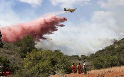 Una avioneta realiza una descarga sobre el frente del incendio forestal cerca de la localidad de Sumacarcer (Valencia), el 16 de junio.
