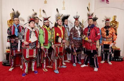 Un grupo de bailarines y cantantes nativos americanos del pueblo Osage, con su indumentaria ceremonial, a su llegada a la alfombra roja.
