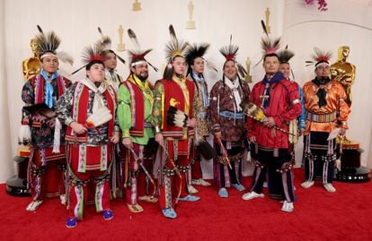Un grupo de bailarines y cantantes nativos americanos del pueblo Osage, con su indumentaria ceremonial, a su llegada a la alfombra roja.