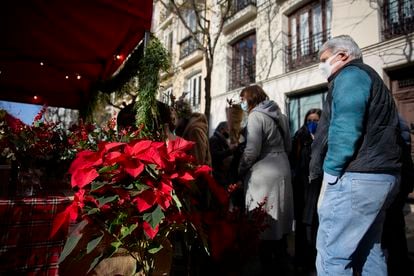 Varias personas acuden a los puestos en un mercado de flores en el barrio de Salamanca, el 18 de diciembre de 2021, en Madrid.