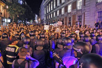 Miles de indignados tratan de alcanzar, a medianoche, la Puerta del Sol a través de la calle Carretas tras marchar por el centro de la capital.