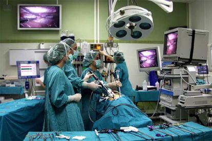 Intervención laparoscópica en la que el cirujano opera a través de pequeñas incisiones y observa sus movimientos en varias pantallas.