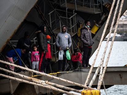 Un grupo de migrantes se asoman al exterior desde un buque griego atracado en el puerto de Mitilene, en la isla de Lesbos. ÁLVARO GARCÍA