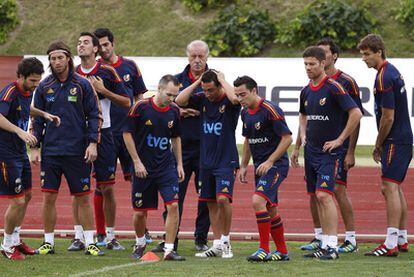 Del Bosque observa a Iniesta, Cazorla y Xavi (en el centro) prepararse para un ejercicio mientras otros jugadores esperan su turno.