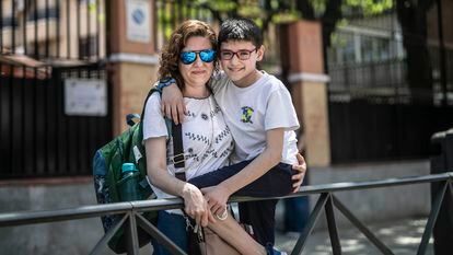 Alicia González y su hijo, frente al colegio con jornada continua del barrio de Villaverde, en Madrid, donde estudia el niño.