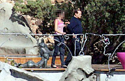 Berlusconi pasea con una mujer por Villa Certosa, en una de las imágenes que publicó EL PAÍS y que fueron censuradas en Italia.