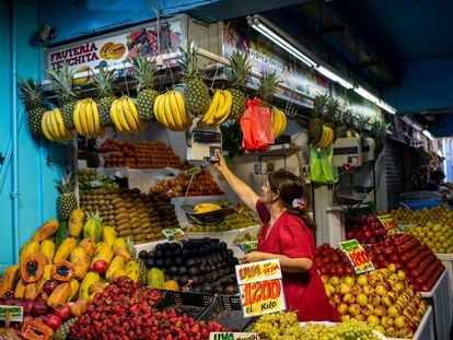 Una mujer pesa fruta en el mercado de La Vega, en Santiago, el 20 de marzo.