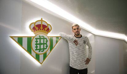 Dani Ceballos posa ante un escudo del Real Betis.