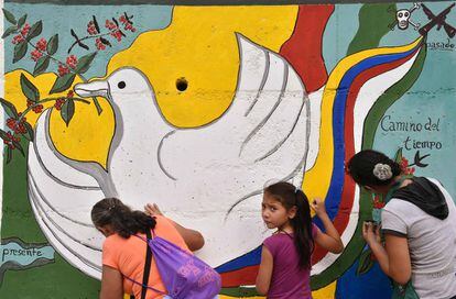 Dos colombianas pintan un mural por la paz.
