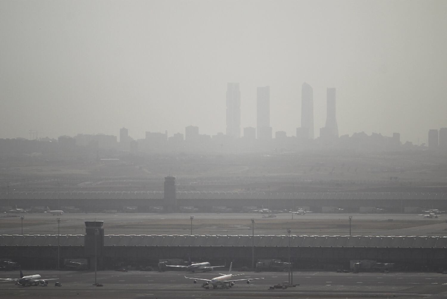 Contaminación por aire subsahariano con el aeropuerto de Barajas en primer término y al fondo las cuatro torres de la Castellana, en diciembre de 2019.