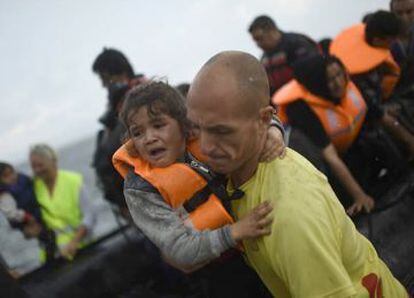 Uno de los socorristas ayuda a una niña refugiada.