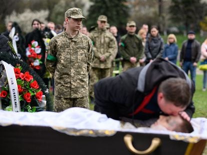 LVIV, UKRAINE - APRIL 26: (EDITORS NOTE: Image depicts death) Hlib Kihitov (L) looks on as his twin brother is kissed by his father Andrii Kihitov during the funeral of 21 year-old Yegor Kihitov, on April 26, 2022 in Lviv, Ukraine. Yegor volunteered in the army but was killed in shelling near Popasna. Lviv has served as a stopover and shelter for the millions of Ukrainians fleeing the Russian invasion, either to the safety of nearby countries or the relative security of western Ukraine. (Photo by Leon Neal/Getty Images)