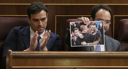Sánchez y Hernando, quien muestra una foto de Rajoy y Rato.