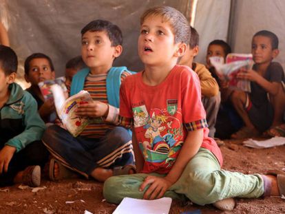 Niños refugiados asisten a clase en el campo de desplazados de Atmeh, en Idlib, al norte de Siria.