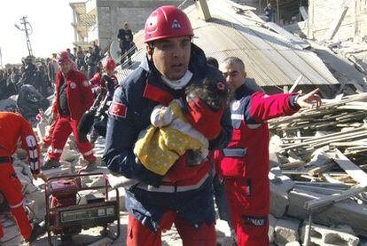 Un socorrista rescata a un bebé localizado en un edificio en ruinas en Ercis, la ciudad más afectada por el seísmo del sureste turco.