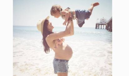 Raquel del Rosario, embarazada, con su primer hijo en brazos. 