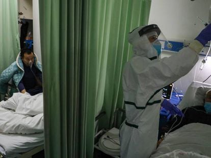 Una enfermera atiende a un afectado por coronavirus en un hospital de Wuhan. En vídeo, ascienden a 724 muertos dentro de China.
