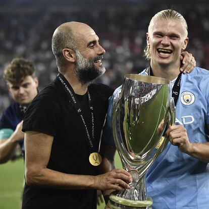 Manchester City's Spanish manager Pep Guardiola (L) holds the trophy with Manchester City's Norwegian striker #09 Erling Haaland after winning the 2023 UEFA Super Cup football match between Manchester City and Sevilla at the Georgios Karaiskakis Stadium in Piraeus on August 16, 2023. (Photo by Spyros BAKALIS / AFP)
